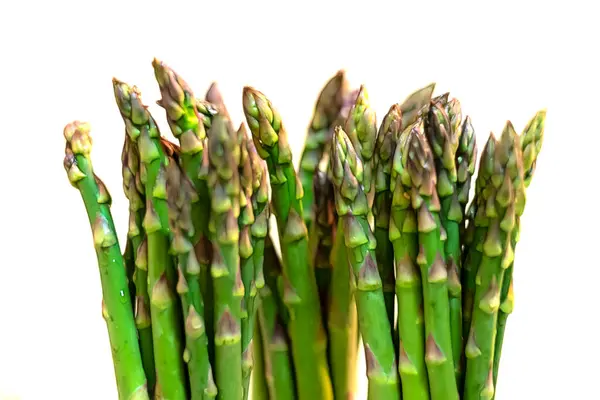 Masanın üzerinde taze yeşil kuşkonmaz resmi var.