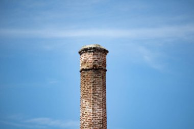 Arka planda mavi gökyüzü olan tuğlalardan yapılmış eski baca