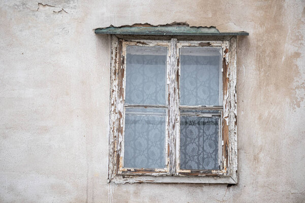 Old window with cracked paint on vintage house facade