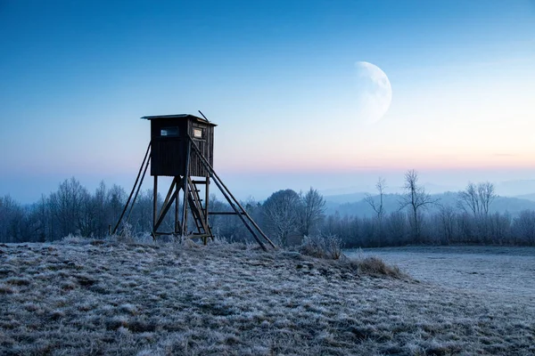 Dřevěná Lovecká Věž Zamrzlým Polem Popředí Měsícem Noční Obloze Pozadí — Stock fotografie