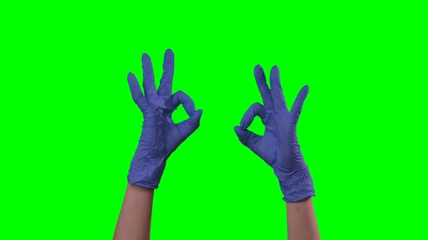 戴着医用蓝手套的女人手举着手势 医生手臂戴防护手套 表示身体好或推荐 在绿屏背景下的特写 — 图库照片