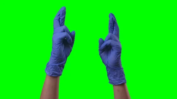 ラテックスブルーの手袋の女性の手が交差指を示している 保護医療用手袋の医師の腕サイン期待 待っていることを示す 緑の画面の背景で閉じる — ストック写真
