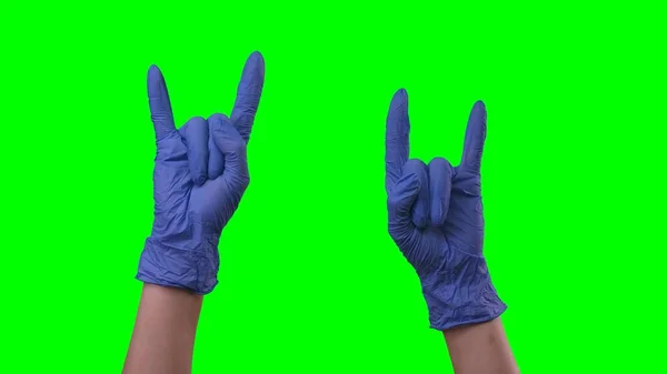 ラテックスブルーの手袋の女性の手は ロックジェスチャーを作っている 生命を楽しむサインを示す保護医療用手袋の医師の腕 緑の画面の背景で閉じる — ストック写真