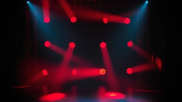 暗闇の中でのディスコやライトショー 赤い青色の明るい光のスポットライトは 煙の多い暗いシーンを照らします 照明器具照明効果 コンサート照明用のランプ ディスコクラブでの光の光線 — ストック写真