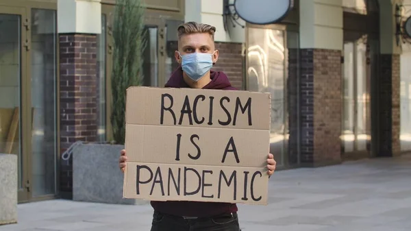 Молодой Человек Медицинской Маске Стоит Картонным Плакатом Racism Pandemic Общественном — стоковое фото