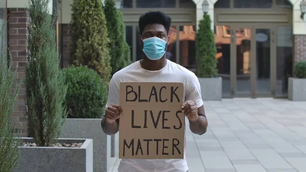 Fiatal Afro Amerikai Férfi Orvosi Maszkban Áll Egy Karton Plakáttal — Stock Fotó