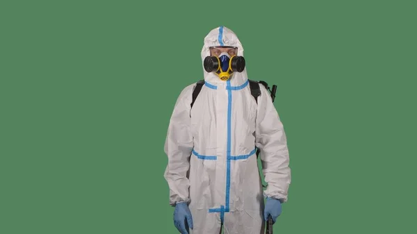 医療用の白いスーツを着た男 カメラを見ているマスクとゴーグル 緑の画面上の医療消毒作業員やウイルス学者 危険なウイルスの発生と戦う — ストック写真