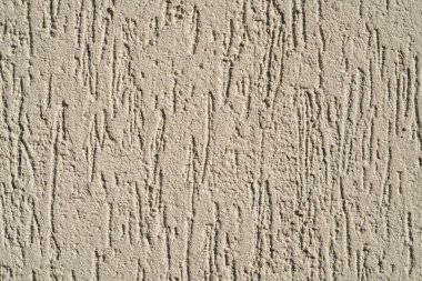 Duvar kabuk böceği desenli gri dekoratif alçıyla kaplı. Evin dış cephesinde beyaz mermer lekeler var. Yapı mermer parçacıklarının makro çekimi, beton