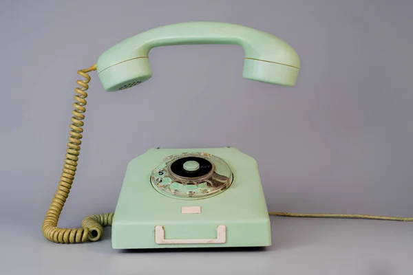 灰色の背景にハンギングレシーバを削除した古い青の高齢者のロータリー電話 ダイヤル ツイストケーブルとレシーバー携帯電話とヴィンテージ固定電話 — ストック写真