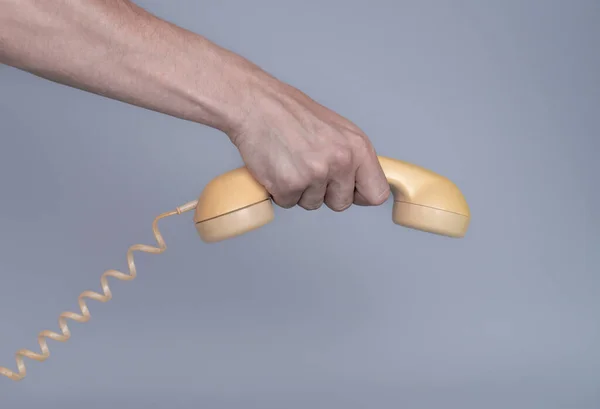 Mão Masculina Segurando Velho Receptor Telefone Plástico Amarelo Fundo Cinza — Fotografia de Stock