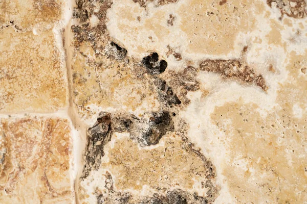 Macro shot of a granite or marble stone structure with brown white marbling and spots. Marble stone surface with texture pattern. Marble countertop, tile, path, wall. Facing stone with marbled spotted