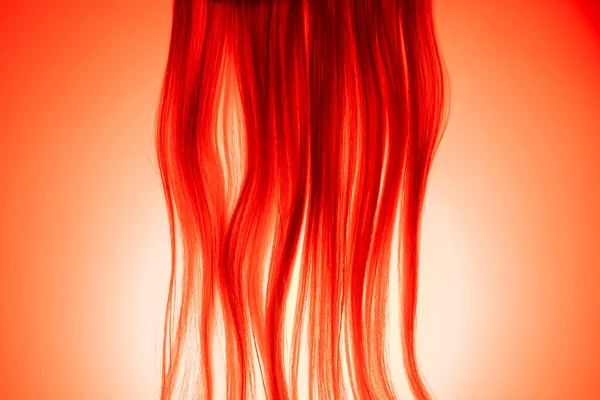 赤い光に照らされたブロンドの髪の一部 軽い女性の髪の帯 健康な自然な女性の髪のヒント 合成ウィッグ 髪の長いストレートロックのマクロショット サロン 理容室のフレーム — ストック写真