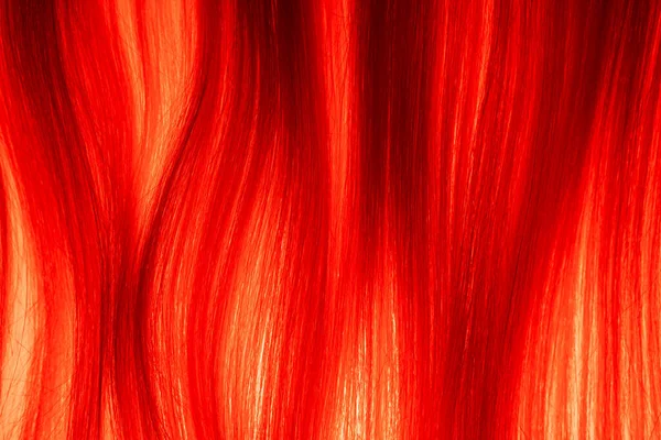 赤い光に照らされたブロンドの櫛状の髪の質感 軽い女性の髪の帯 健康な自然な女性の髪のカール 合成ウィッグ 髪の長いストレートロックのマクロショット サロンの枠 — ストック写真