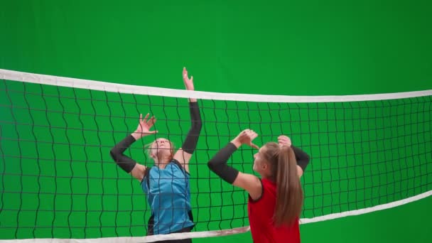 两名穿着运动服的年轻女子在绿屏彩色键上打排球 女运动员进球得分并高兴 而对手则射失了球 很不高兴 实施攻击和防御技能 — 图库视频影像