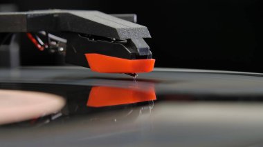 Siyah arka planda eski vinil çalar. Siyah kırmızı bir tonkolun iğneli bir müzik eşliğinde makro çekimi. İğne kayıttaki oluklara değiyor. Nostalji anlayışı, retro ekipmanlar, eski DJ turntable