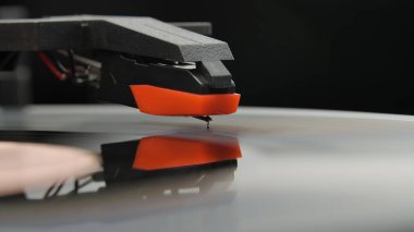 Siyah arka planda eski vinil çalar. Siyah kırmızı bir tonkolun iğneli bir müzik eşliğinde makro çekimi. İğne kayıttaki oluklara değiyor. Nostalji anlayışı, retro ekipmanlar, eski DJ turntable