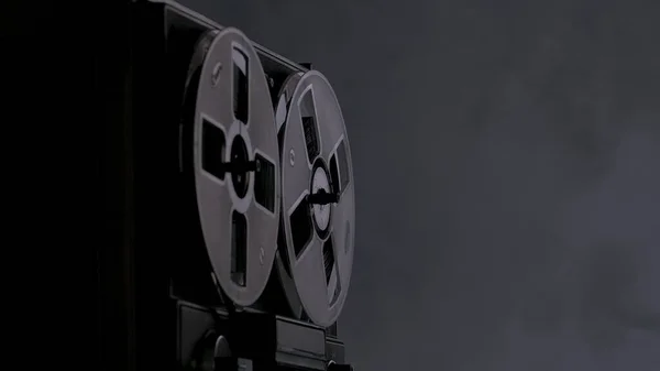 在黑烟熏陶的工作室背景上旋转卷轴录音机 具有磁带卷轴的模拟古董唱机 用于播放音乐 黑暗中的旧圆筒 复古派对 — 图库照片