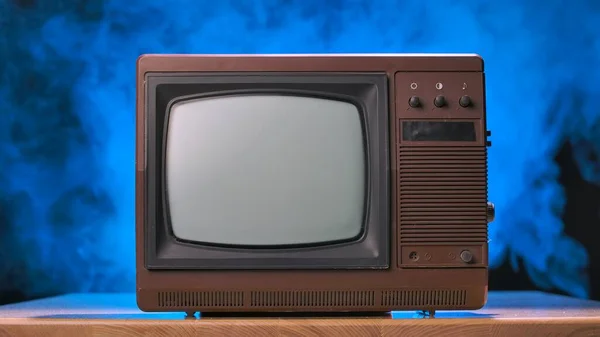 Alter Fernseher Auf Einem Holztisch Vor Schwarzem Studiohintergrund Mit Blauem — Stockfoto