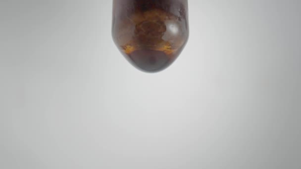 茶色の液体のドロップ 血清またはグレーの背景にピペットから滴下チンキ ヨウ素やエッセンシャルオイルの滴下のマクロショット 薬の概念 アロマハーブ — ストック動画