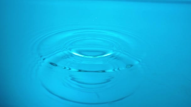 Macro Tiro Uma Gota Água Cai Uma Superfície Líquida Azul — Vídeo de Stock