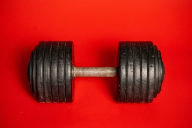 Ağırlık Antrenmanı Ekipmanı. Rengarenk kırmızı arka planda duran ağır ağırlıklı siyah halterler. Vücut geliştirme için atletik halter, yaya geçidi, güç antrenmanı. Spor salonunda egzersiz, fitness. Konsept