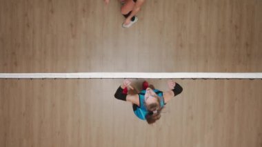 Çocuk parkında voleybol oynayan iki genç bayan sporcu. Voleybol oyuncusunun topu blokçunun elinden geçirdiği en iyi görüntü. Mavi ve kırmızı üniformalı bayan oyuncular pratik yapıyor ve...
