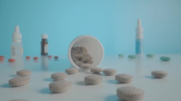 Ronde Grijze Pillen Verspreid Uit Fles Tafel Blauwe Achtergrond Camera — Stockvideo