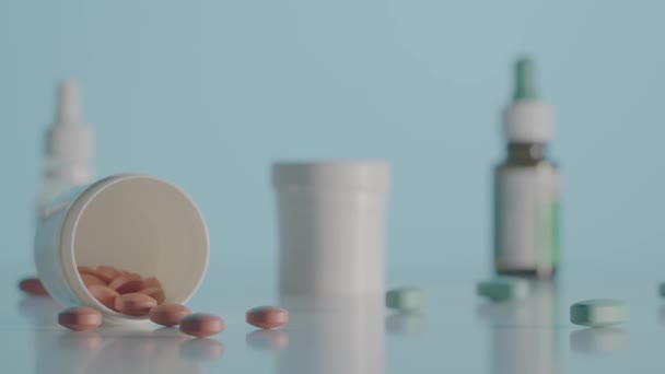 圆形的棕色药丸分散在蓝色背景的桌子上 带着药片和各种药瓶的相机在桌子上移动 关闭维生素 抗生素或止痛药 慢动作 — 图库视频影像