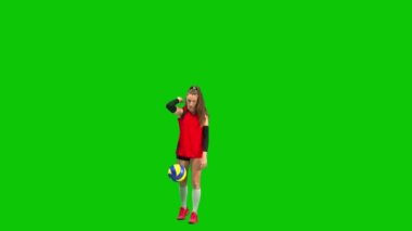 Siyah ve kırmızı spor üniformalı bayan voleybol oyuncusu topa yere vuruyor ve sonra avucuyla topa vuruyor. Yeşil ekranda çalışma alanı olan uzun boylu genç bir kadın. Voleybol yeteneklerini geliştiriyorum.