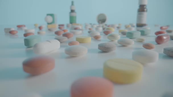 様々な薬 カプセルや錠剤は 医療用ボトルと青い背景にテーブルの上に散在しています 白と黄色の薬 鎮痛剤 ビタミンや抗生物質が閉じます — ストック動画
