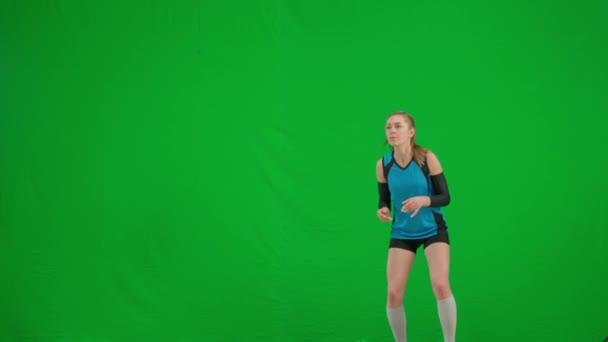 年轻女子弹跳 摔倒在地板上 运动员在绿色荧幕上打排球 比赛期间身穿蓝色和黑色运动服的排球女选手 — 图库视频影像