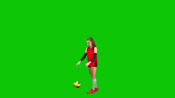 黒と赤のスポーツユニフォームを着た女子バレーボール選手が床にボールを打ち 手のひらでボールを打つ ワークスペースと緑の画面上の完全な長さの若い女性 バレーボールの練習 — ストック動画