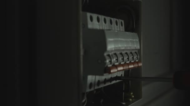 Электрик Собирает Электрическую Панель Темноте Закройте Руки Человека Затягивающего Винт — стоковое видео