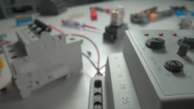 Faz kontrol rölesi ve elektromanyetik bobinler ile masada alternatif akım. Beyaz metal kaplamalı ekipmanları kapatın, düğmeleri çevirin, düğmeleri çevirin, tornavidaları kullanın.