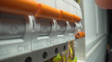 Santraldeki yüksek voltajlı elektrik düğmelerini açan parmak. Otomatik sigorta kutusu var. Kapatın, elektrik düğmesi açık. Devre kesicileri aç. Otomatik şalterler açılıyor