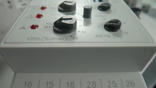相控控制继电器放在桌上 关闭设备与白色金属外壳 黑色开关按钮和旋转旋钮 红色和绿色指示灯 车间的电工电动工具 实验室 — 图库视频影像