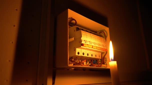 电工通过点燃的蜡烛在黑暗中组装电板 用螺丝刀紧紧抓住一个人的手 打开开关柜中的高压电源开关 — 图库视频影像