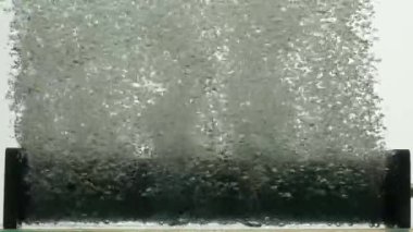 Hava kabarcıkları akvaryumdaki karanlık paralon kompresör tüpünden ya da su altındaki filtrelerden fışkırıyor. Beyaz zemin üzerinde sıvıdaki yükselen oksijen kabarcıklarına yakın çekim. Havalandırma için çalışma ekipmanları