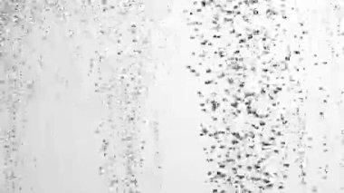 Aşağıdan yüzeye beyaz izole edilmiş arka planda bir sürü küçük siyah hava kabarcığı yükseliyor. Oksijen baloncuklarının suyun altından yukarı doğru akışını kapatın. Sıvının havalanması veya filtrelenmesi. Fizzy akışı