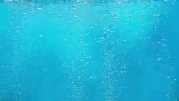 光沢のある空気は海底から水面に上昇し 光の光線によって照らされます 青い海や海の水の酸素泡のストリーム 空気中の泡状の液体の閉じ込め — ストック動画