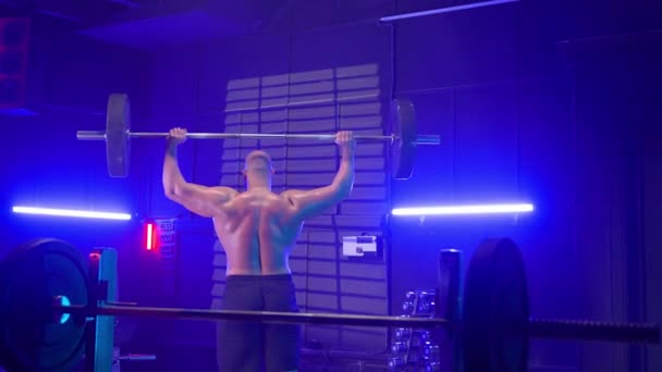 Back View Sporty Bodybuilder Lifting Barbell His Head Dark Gym — Stock Video
