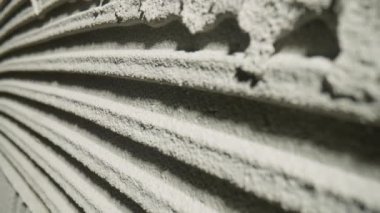 Çentikli mala desenli taze beton tehture kamera hareketi. Duvarda çizgili ya da çizgili gri çimento macunu var. Seramik fayanslar için havan mermisi yapıştırıcısı
