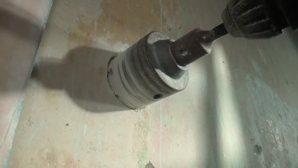 灰色のコンクリート壁にソケットのための丸い穴を掘削 電気ドリルまたはパフォーマーで回転する丸いノズルカップ ドリルで穴あけする際には 石膏からの白いほこりが崩れます コンセプト — ストック動画