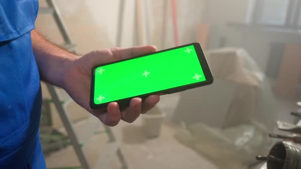 Manlig Byggare Håller Pekskärm Smartphone Med Grön Skärm Kroma Nyckel — Stockvideo