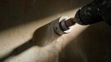Beton duvarda delik açmak için makro atış. Elektrikli matkap veya delgi üzerinde dönen metal yuvarlak başlık. Alçı parçalarından beyaz tozu delme işlemi sırasında. Kavram
