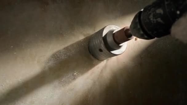 コンクリート壁にソケットの穴あけラウンドホールのマクロショット 電動ドリルやパフォーマーで回転する金属ラウンドノズルカップ 石膏から白い塵を掘削する過程で崩れます コンセプト — ストック動画