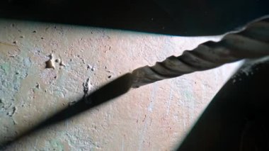 Elektrikli matkapla delme işlemi ya da ışık demeti ile karanlıkta delme işlemi. Metal spiral matkabın makro görüntüsü dönüyor. Delme işlemi sırasında, alçıdan beyaz toz