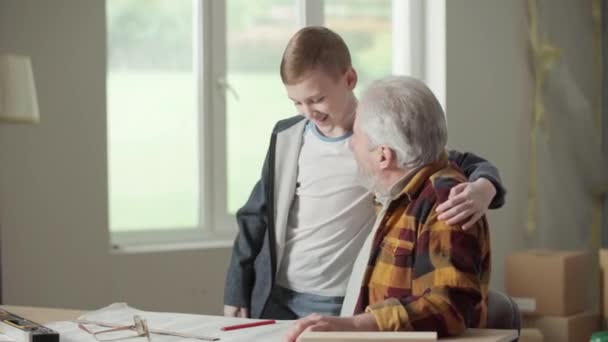 Εγγονός Φιλικό Αγκαλιάζει Τον Παππού Του Οποίος Δείχνει Και Εξηγεί — Αρχείο Βίντεο
