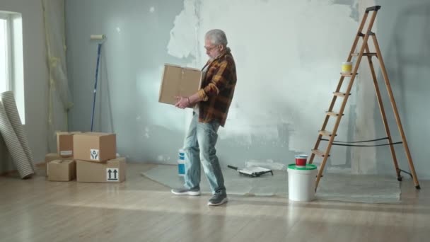 Elderly Man Carrying Heavy Cardboard Box Placing Floor Worried Back — Videoclip de stoc