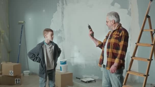 Grandpa Showing His Grandson How Electric Cordless Screwdriver Works Elderly — стокове відео